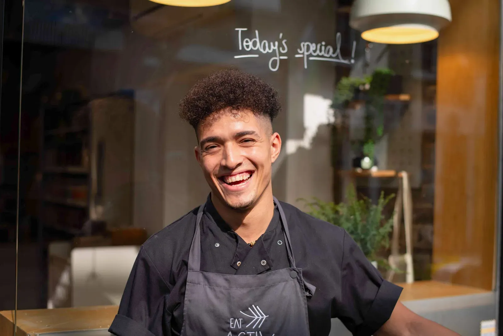 A chef smiling through the window
